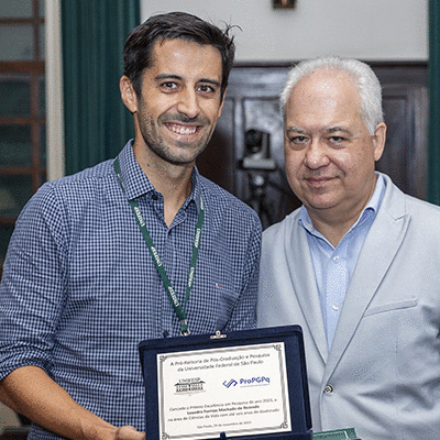 Prof. Leandro segurando seu Prêmio Excelência em Pesquisa